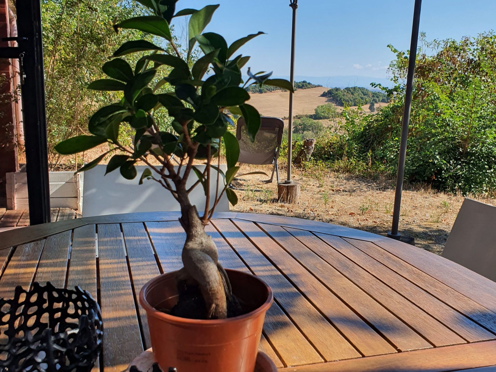 Terrasse avec table et chaises extérieures, vue montagne noire