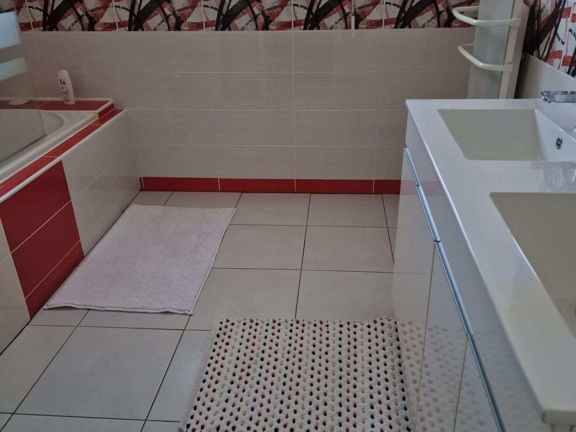 Salle de bain avec baignoire, double vasques, attenante à la chambre.